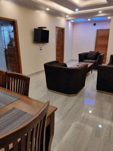 a room with couches and chairs and a flat screen tv at Superb Luxury Three Bed Apartment in Shimla