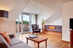 ein Wohnzimmer mit einem Sofa und einem Tisch in der Unterkunft Kultur & SPA Hotel Das Götzfried in Regensburg