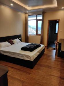 a bedroom with a bed and a large window at Superb Luxury Three Bed Apartment in Shimla +35 photos