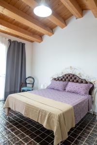 una camera con letto viola e soffitto in legno di Delta House a Taglio di Po