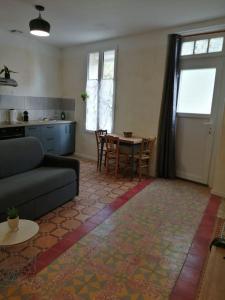 a living room with a couch and a table at Loré Appartement Climatisé avec terrasse in Ortaffa