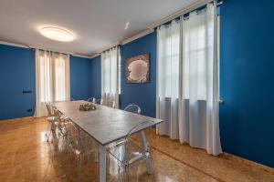 comedor con paredes azules, mesa y sillas en Villa Cornelia , entire Villa with private pool, en Corneliano d'Alba