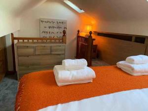 two white towels sitting on top of a bed at Wyresdale 7 Limethwaite in Windermere
