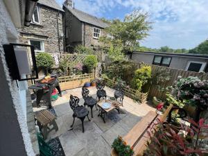 a patio with chairs and tables in a backyard at Wyresdale 7 Limethwaite in Windermere
