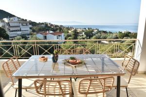 a table on a balcony with a view of the ocean at SUNRISE LUXURY POOL VILLA in Paleo Tsifliki