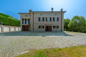une grande allée en pierre devant un bâtiment dans l'établissement Villa Cornelia , entire Villa with private pool, à Corneliano d'Alba