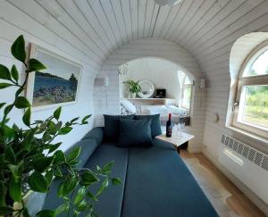 una sala de estar con un sofá azul en una habitación blanca en Igluhut on the South Coast of Lohusalu 200m from the Sea! en Lohusalu