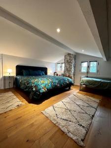 a bedroom with a bed and two rugs at La suite avec jacuzzi in Saint-Martin-de-Londres