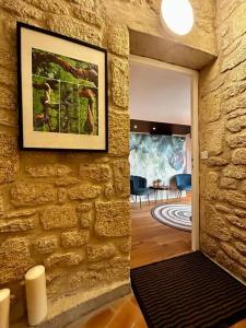 a room with a stone wall with a painting on it at La suite avec jacuzzi in Saint-Martin-de-Londres