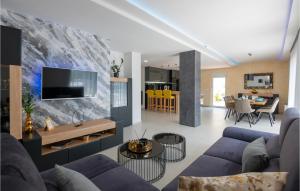 uma sala de estar com um sofá azul e uma televisão em Awesome Home In Donji Vinjani With Kitchen em Topići