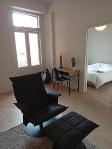 a living room with a black chair and a bed at Citylux Verdandi in Turku