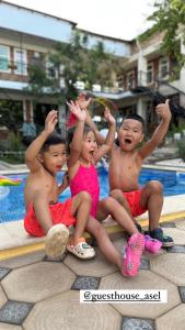 喬爾蓬阿塔的住宿－Гостевой дом Асель，一群儿童坐在游泳池旁