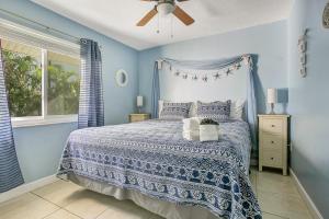 清水海灘的住宿－Five Palms Vacation Rentals- Daily - Weekly - Monthly，蓝色卧室配有床和吊扇