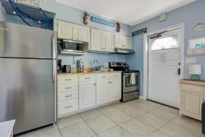 a kitchen with white cabinets and a stainless steel refrigerator at Five Palms Vacation Rentals- Daily - Weekly - Monthly in Clearwater Beach