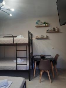 Zimmer mit 2 Etagenbetten, einem Tisch und einem Stuhl in der Unterkunft Sweet Maison Apartment in Paralia Katerinis