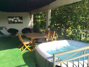 a hot tub on a patio with a table and chairs at LE PANORAMA et son SPA in Tulle