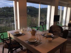 una mesa de madera con platos y vasos en el balcón en LE PANORAMA et son SPA en Tulle