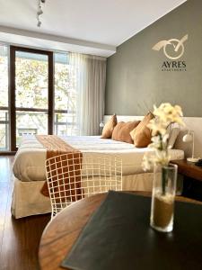 una habitación de hotel con 2 camas y una mesa con flores en Ayres Apartments Palermo en Buenos Aires