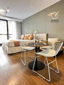 a bedroom with a bed and a table and chairs at Ayres Apartments Palermo in Buenos Aires