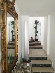 - un miroir et des escaliers dans une chambre avec des palmiers dans l'établissement carmencamere, à Porto Recanati