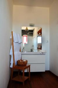 een badkamer met een wastafel, een spiegel en een mand bij Herdade da Burquilheira in Alcáçovas