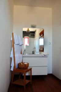 un bagno con lavandino, specchio e cesto di Herdade da Burquilheira Family Retreat ad Alcáçovas