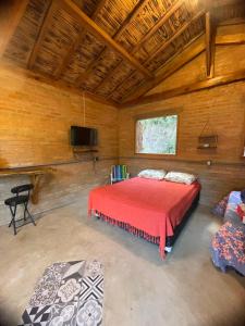 ein Schlafzimmer mit einem Bett und einem TV in einem Zimmer in der Unterkunft CAFOFO DA GIO in Conceição da Ibitipoca