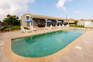 ein großer Pool mit Stühlen und Sonnenschirmen in der Unterkunft Perladelmare in Avola