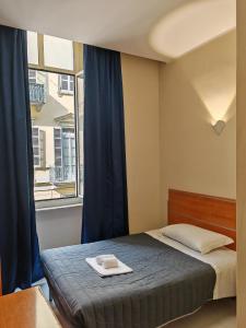 a bedroom with a bed and a window at Hotel Romano in Turin