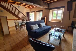 a living room with a blue couch and a table at Chez Lili Maison de campagne gîte familial in Saint-Mesmin +27 photos