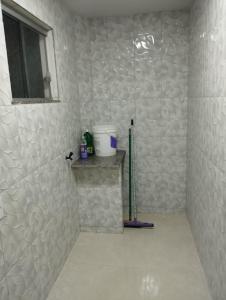 a bathroom with a shower with a white tiled wall at Residencial Casa Grande Apto 04 in Santa Cruz Cabrália