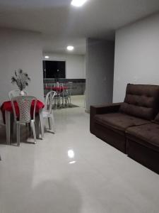 a living room with a couch and a table and chairs at Residencial Casa Grande - Apto 04 in Santa Cruz Cabrália
