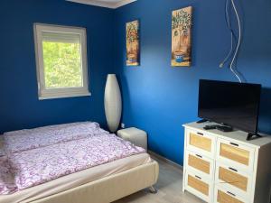 a bedroom with a bed and a flat screen tv at Pentz House in Siófok