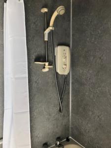 a shower in a bathroom with a shower head at The Old Post Office House BnB in Balmacara