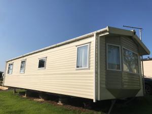 a mobile home is parked in a yard at Lovely Holiday Caravan, great location - Pebble Bank, near Chesil Beach in Wyke Regis +4 photos