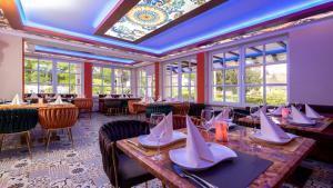 a dining room with tables and chairs and windows at Park Hotel Berlin in Bad Fallingbostel