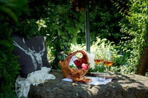 a picnic table with glasses of wine and a basket at Garden & SPA Hotel Das Götzfried in Regensburg