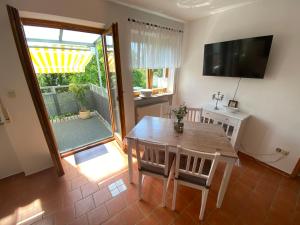 a dining room with a table and a television at GHR Apartment in Simbach am Inn