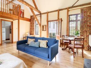 a blue couch in a living room with a table at Cart Wheel Cottage in Braintree