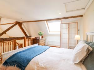a bedroom with a large bed and a window at Cart Wheel Cottage in Braintree