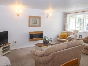 a living room with a couch and a tv at Rose Cottage in Paignton