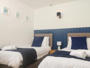 two beds in a room with blue and white at Rose Cottage in Paignton +20 photos