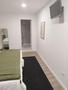 Zimmer mit einem Bett und einem TV an der Wand in der Unterkunft BUS STATION Suites & Studios in Coimbra
