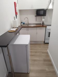 a kitchen with white cabinets and a counter top at BUS STATION Suites & Studios in Coimbra