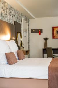 a bedroom with a large white bed and a table at Hotel Veere in Veere