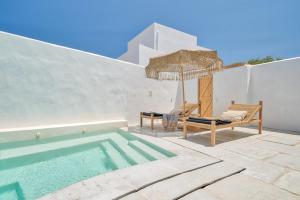 a swimming pool with a chair and an umbrella at Villa Yialos in Antiparos