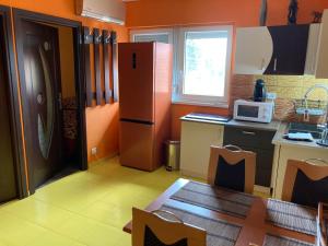a kitchen with orange walls and a refrigerator and a table at Pentz House in Siófok