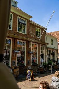 a building with people sitting in front of it at Hotel Veere in Veere