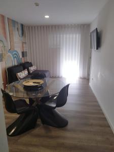 un soggiorno con tavolo e sedie in vetro di BUS STATION Suites & Studios a Coimbra