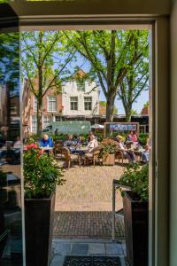 un gruppo di persone seduti ai tavoli in un patio di Hotel Veere a Veere